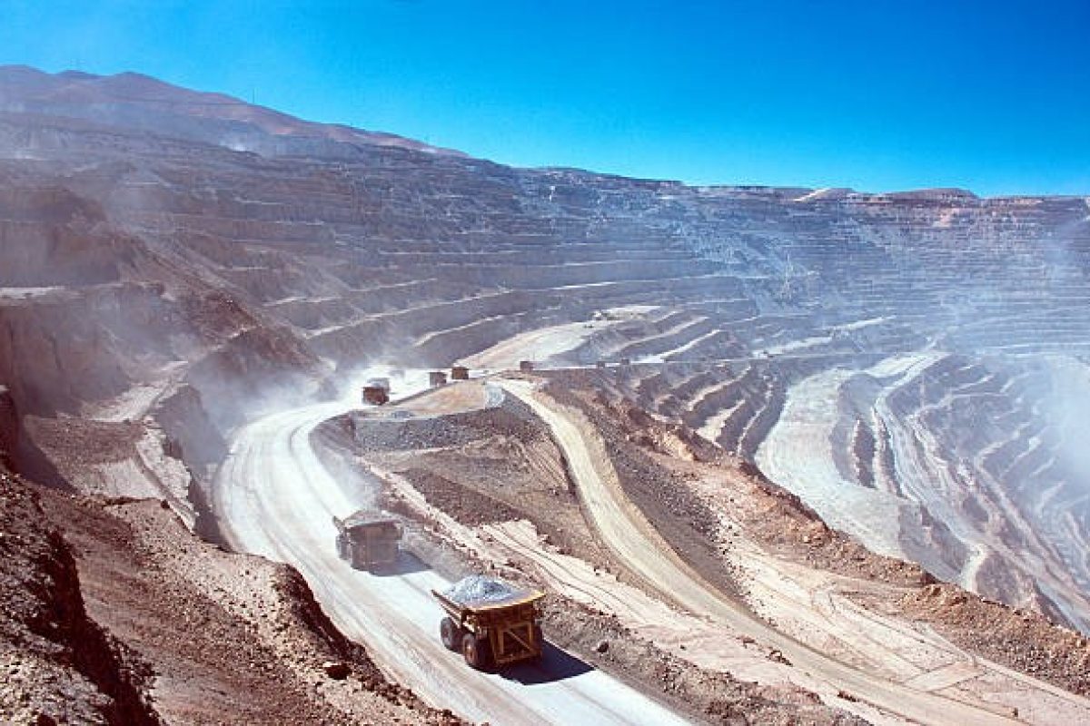 Une grande quantité de poussière vue sur un site minier, des camions à benne basculante